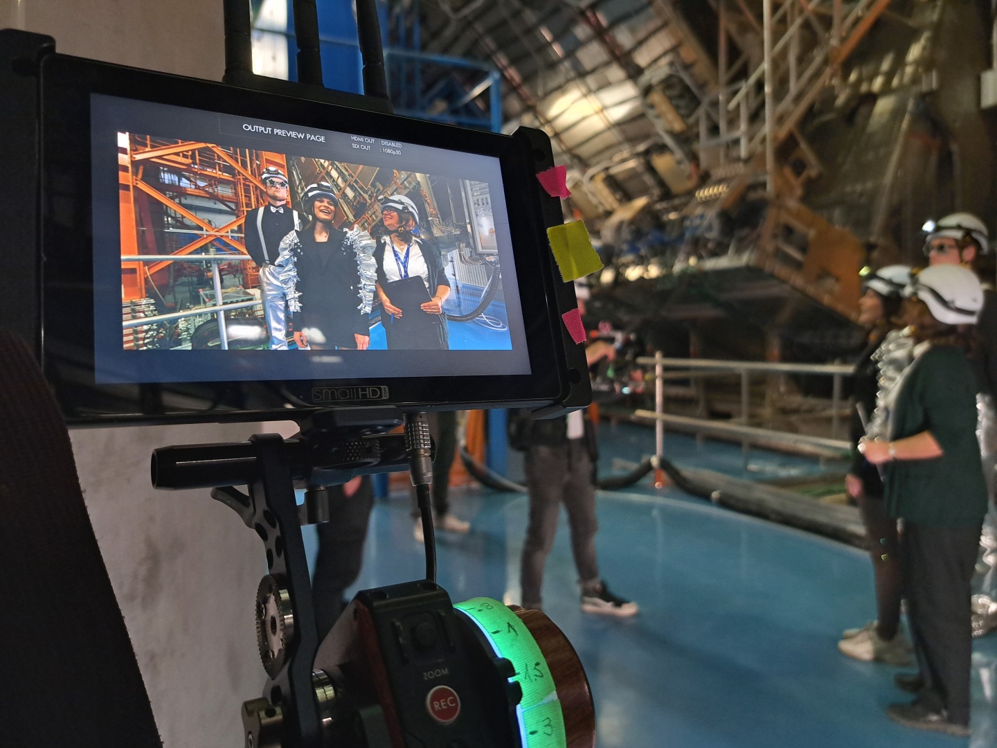 3 people appear on a camera screen