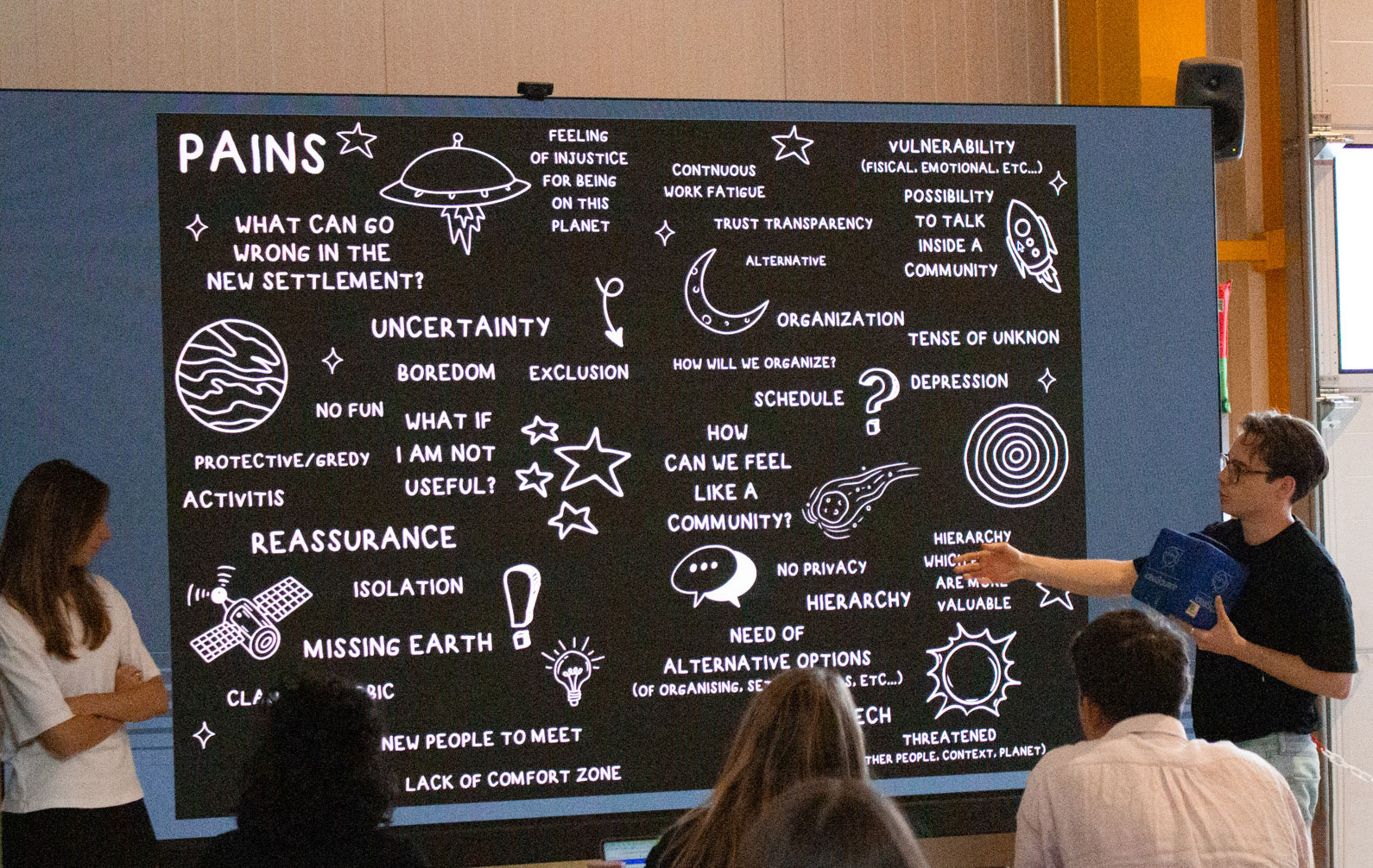 Students reflecting on the challenges humanity might face in establishing life on an exoplanet, in front of a blackboard with ideas such as reassurance, uncertainty, boredom, depression, how can we feel like a community (image: CERN)