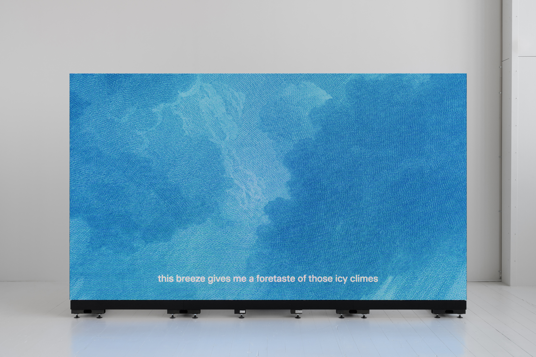 A big blue screen in front of a white background. The subtitles say 