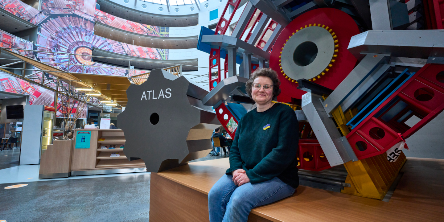 Tetiana, an ATLAS physicist, in front of a model of the ATLAS detector