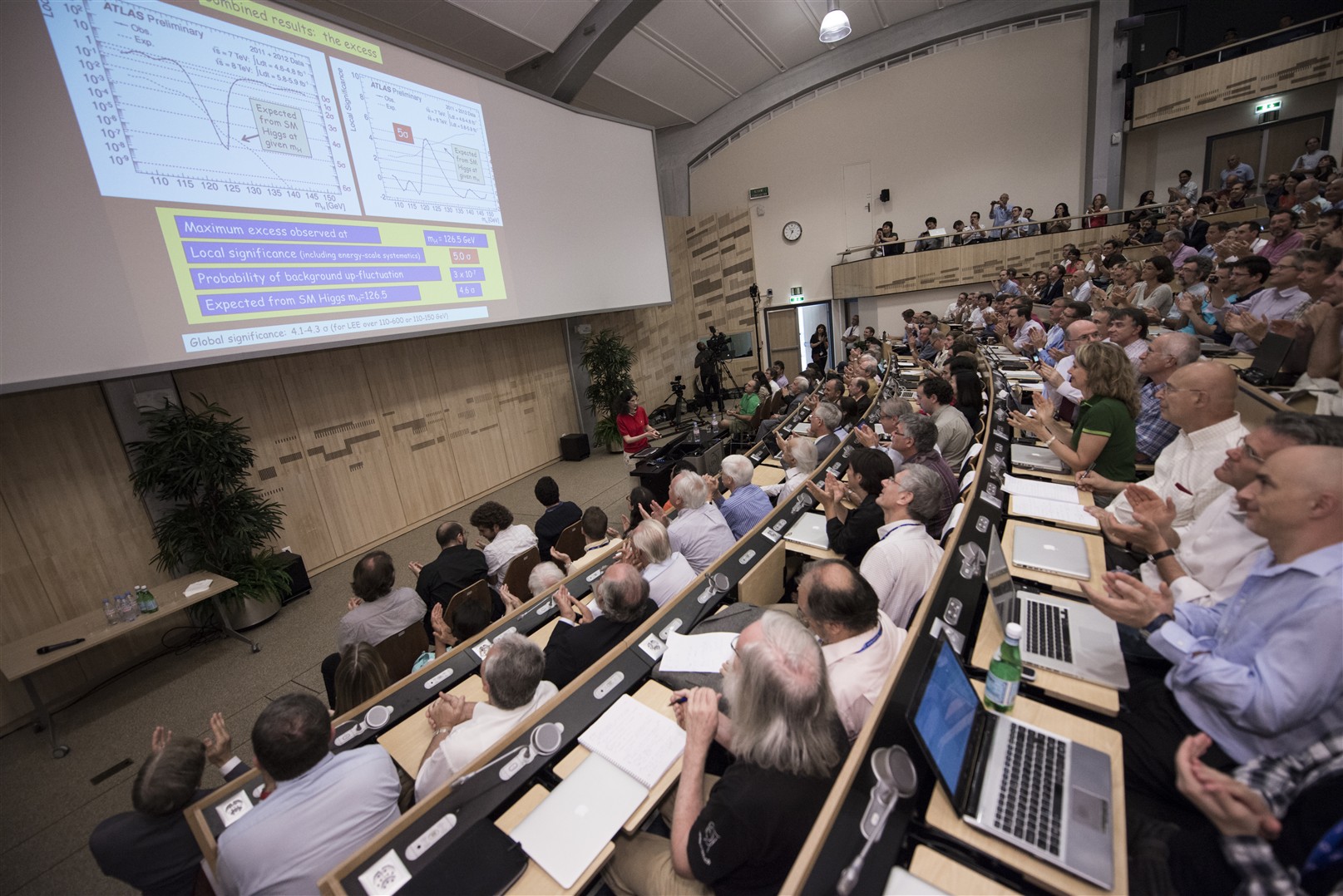 Female presenting to a large crowd in an auditorium