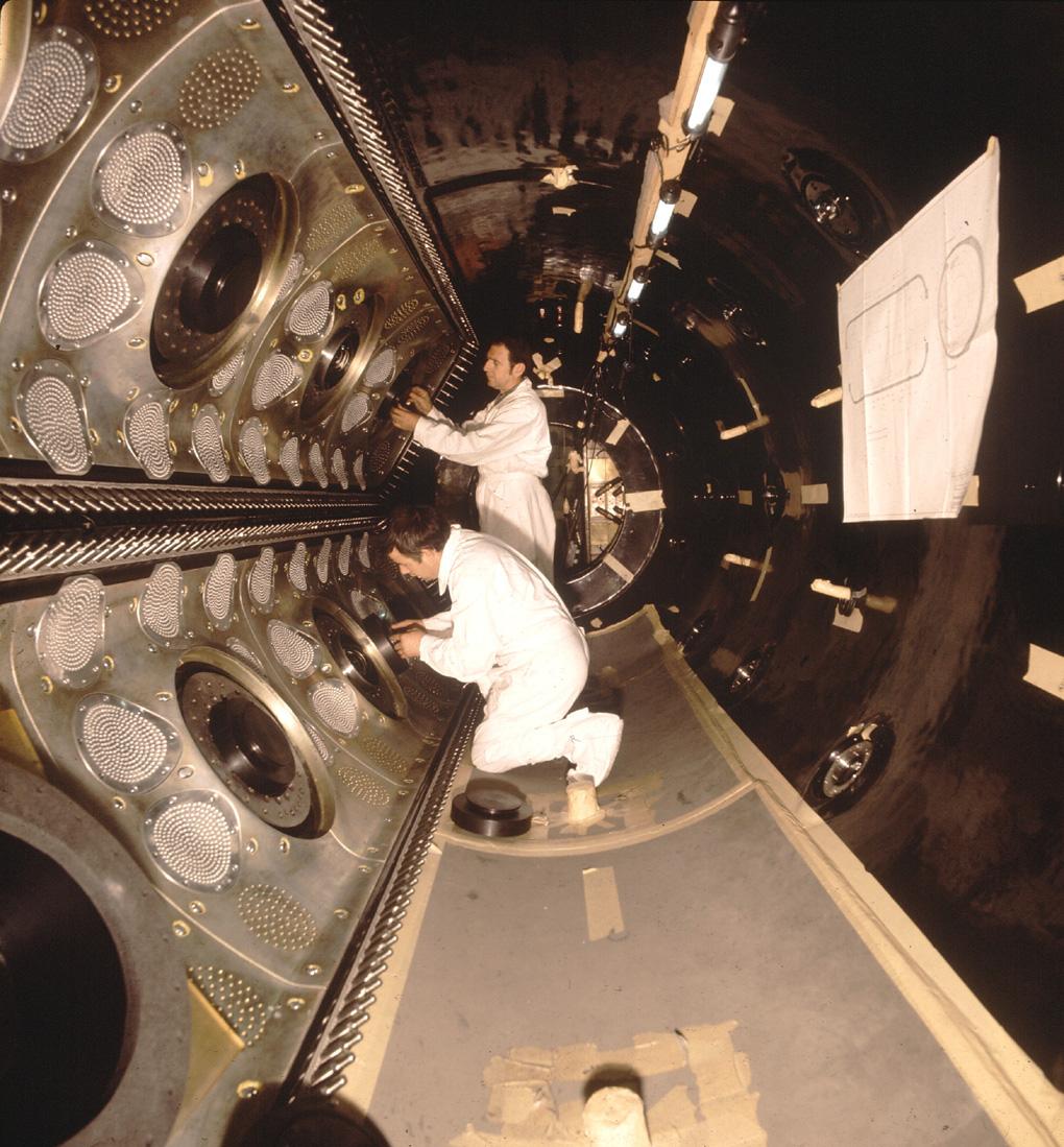 Two men working inside the Gargamelle bubble chamber