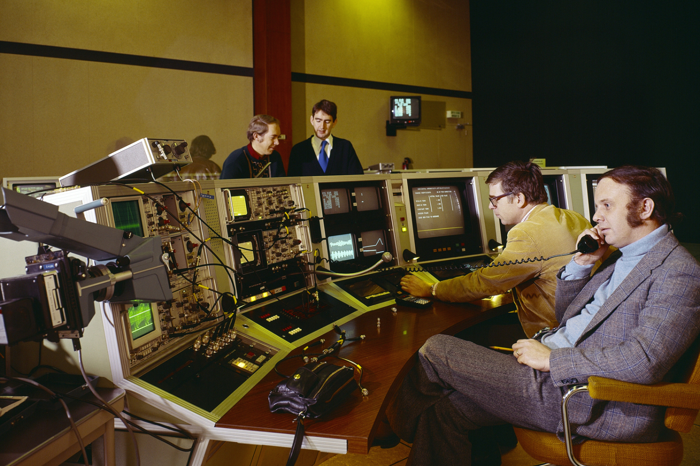 four men in a control room