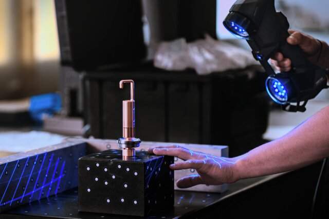 “Precision” by Clemens Sill. A metrology expert at work: the laser scanner device in his hand helps him to quickly determine the dimensions of this custom object.