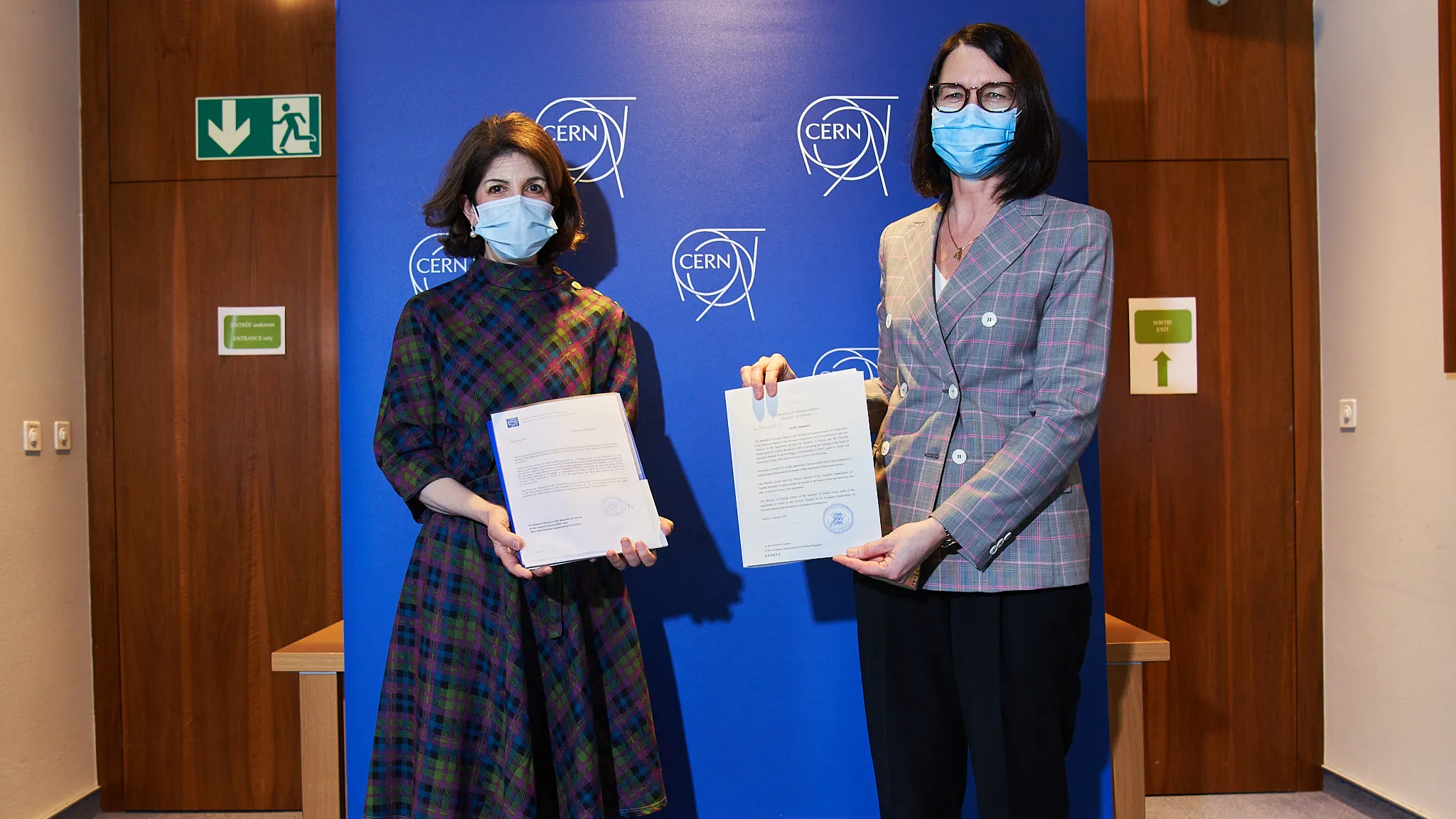Two female officials holding the letter
