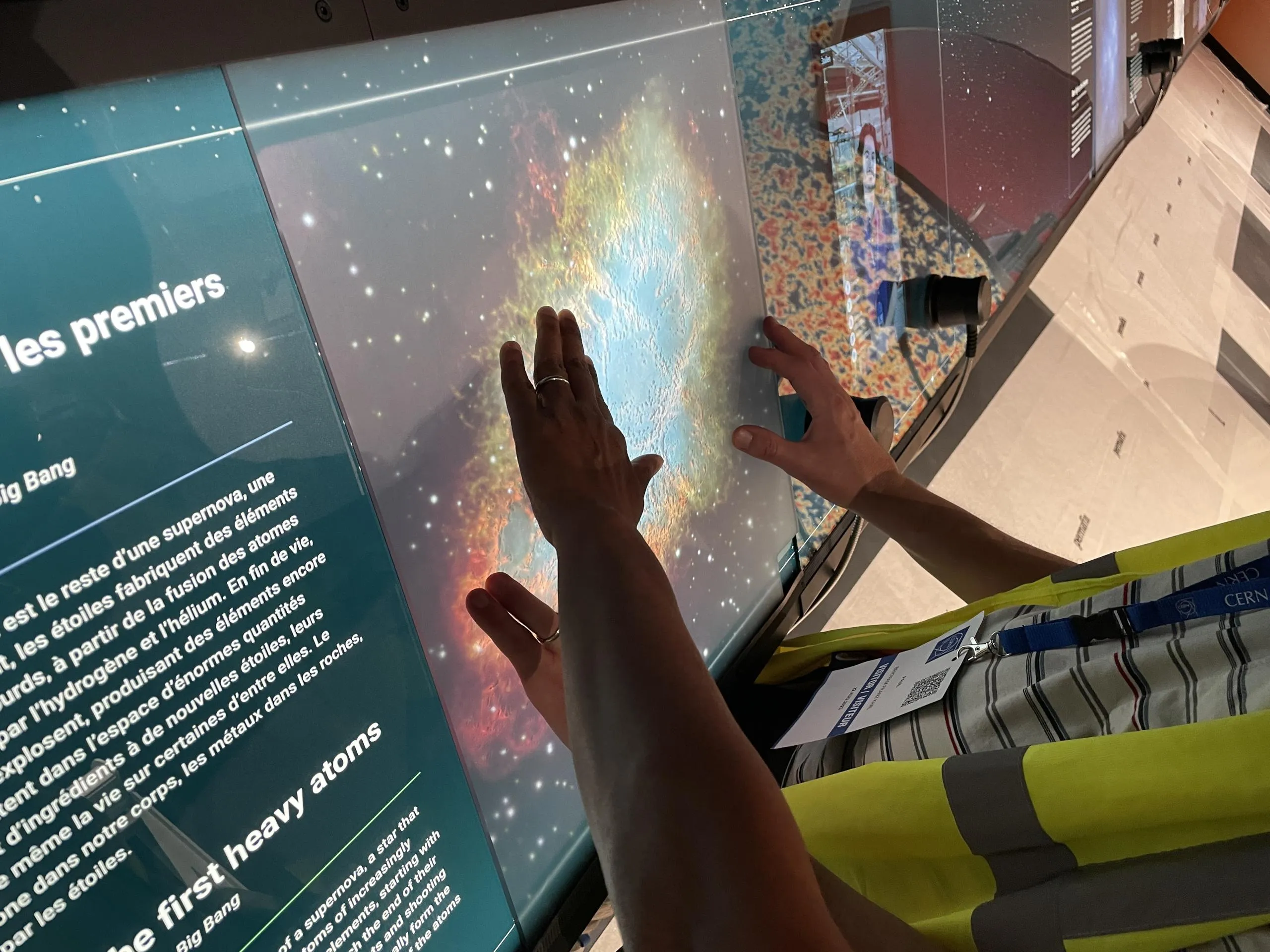 hands touching an image of a nebula in relief