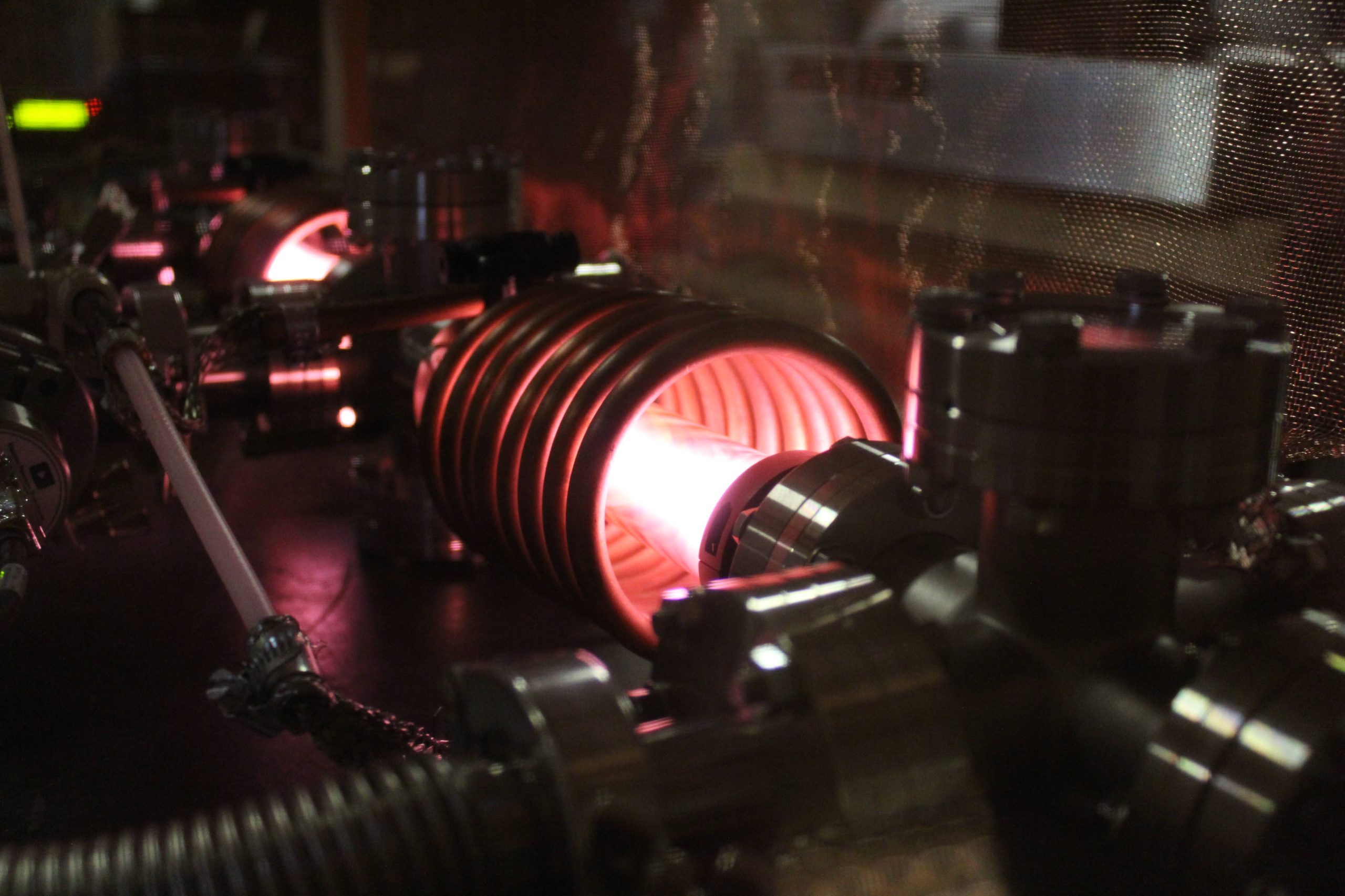 Metal coil with glowing red light running through the centre.
